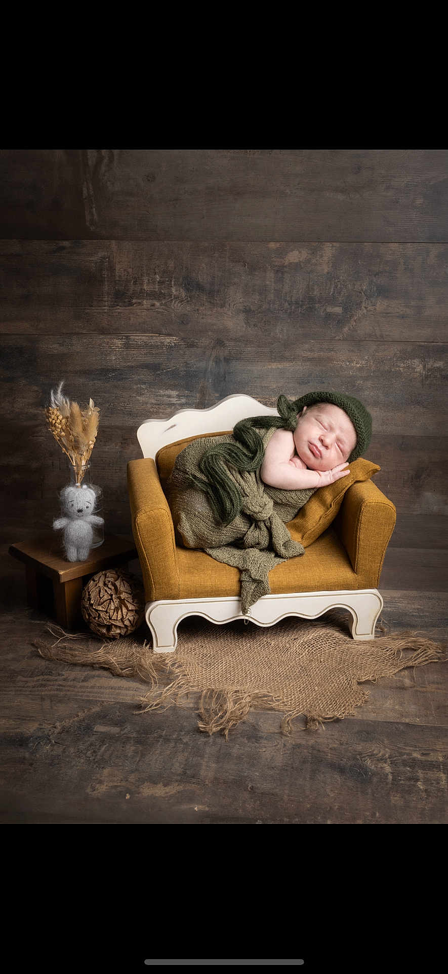 Aaron participe au concours pour gagner de l'argent avec cette photo : newborn, baby, sleeping, knitwear, green, couch, vintage, mustard_yellow, wooden_floor, wooden_wall, teddy_bear, dried_flowers, side_table, cozy, portrait, indoors, resting, soft_light, child, wrapped