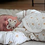 Aaron a rejoint le concours — aidez-le/la à gagner de superbes lots ! baby, sleeping, pacifier, white_clothing, patterned_clothing, infant, cozy, soft_texture, close_up, resting, cute, peaceful, indoor, child, newborn, face, hand, blanket, quiet, comfort