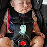 baby, sleeping, car_seat, harness, pacifier, child, infant, seatbelt, safety, cute, chubby_cheeks, relaxed, indoors, black, clothing, person, closeup, young_child, seat, resting