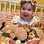 Madison joined the competition — help win amazing prizes! baby, child, infant, smiling, headband, plush_toy, crib, blanket, feet, happy, blue_eyes, clothing, sitting, indoors, cute, person, toy, patterned, head, toddler
