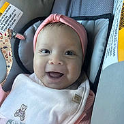 Mia joined the competition — help win amazing prizes! baby, smiling, headband, bib, car_seat, pink, infant, happy, child, face, closeup, cute, clothing, seatbelt, safety, indoors, person, portrait, baby_girl, soft
