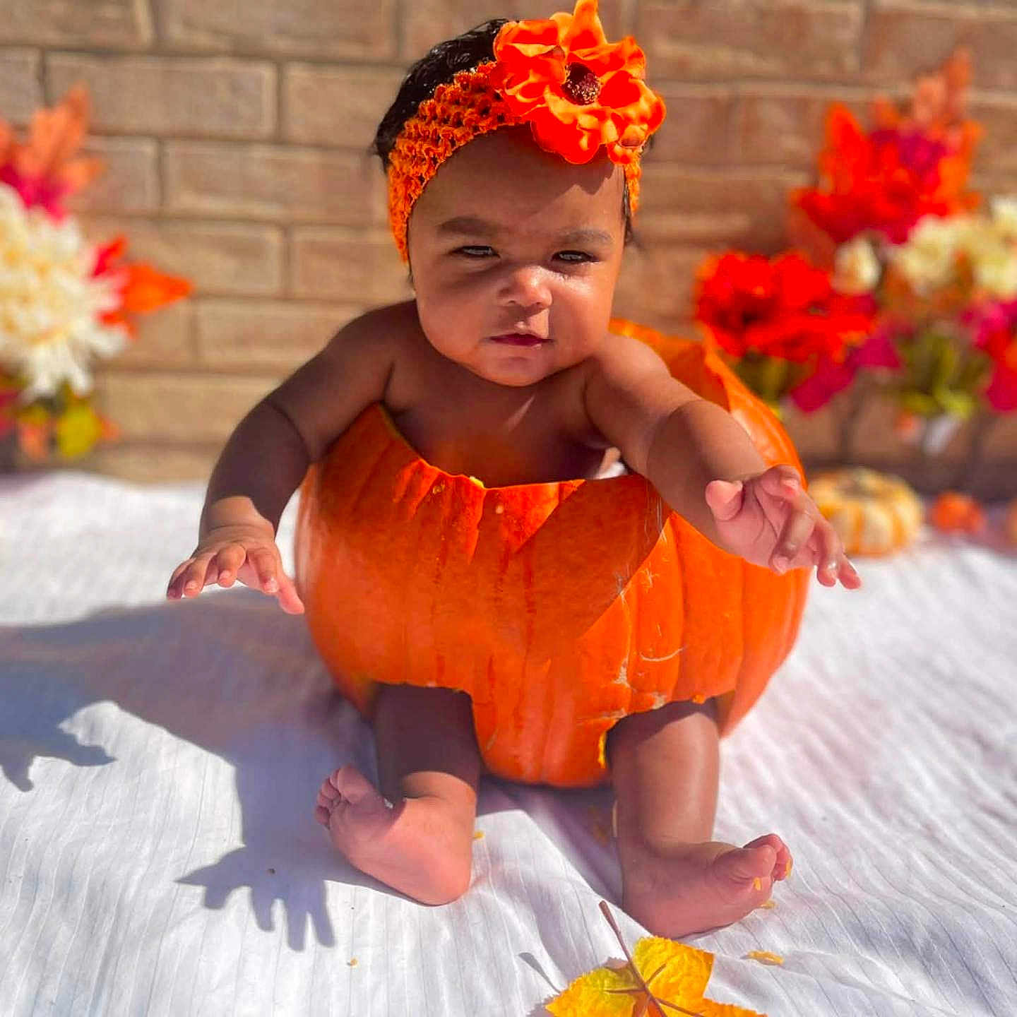 Isleya joined the competition — help win amazing prizes! baby, child, infant, portrait, sitting, orange_costume, pumpkin_costume, flower_crown, flowers, autumn, mini_pumpkins, brick_wall, outdoor, blanket, festive, seasonal, colorful, baby_photography, smiling, feet