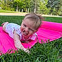 baby, child, grass, pink_mat, tongue_out, outdoor, greenery, playful, cute, smiling, person, nature, summer, infant, happy, toddler, daylight, park, grass_blades, casual_clothing