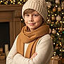 child, boy, winter_hat, scarf, knitted_sweater, holiday, christmas_tree, decorations, lights, smile, indoor, warm_clothing, festive, holiday_season, present, cozy, portrait, holiday_decor, crossed_arms, happy