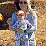 Lilianna joined the competition — help win amazing prizes! baby, infant, woman, adult, mother, smiling, sunglasses, bow, floral_outfit, fall, autumn, hay_bales, farm, outdoor, portrait, family, holding_baby, fashion, sunlight, text_overlay