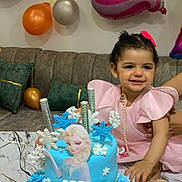 Woujoud a rejoint le concours — aidez-le/la à gagner de superbes lots ! child, toddler, birthday_cake, frozen_theme, blue_cake, balloons, pink_dress, smiling, party, celebration, sofa, cushions, table, decorations, snowflakes, happy, indoors, cake_decoration, person, festive