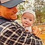 Ellis joined the competition — help win amazing prizes! baby, child, man, outdoor, smiling, holding, hat, cap, plaid_shirt, face, person, nature, trees, fence, autumn, happy, closeup, portrait, young_adult, family