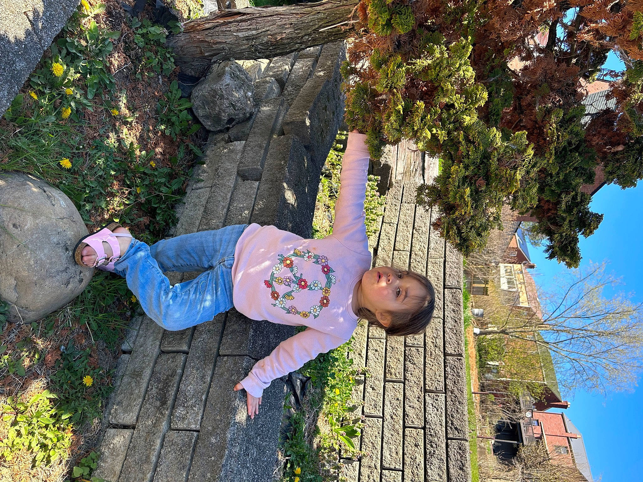 Kiara joined the competition — help win amazing prizes! blue, child, fun, garden, grass, happy, lawn_ornament, leaf, leisure, people_in_nature, person, plant, sky, smile, t_shirt, toddler, tree, vacation, wall, wood