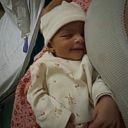 Adèle a rejoint le concours — aidez-le/la à gagner de superbes lots ! baby, newborn, sleeping, smiling, infant, hat, clothing, person, hand, blanket, pattern, floral, comfort, cozy, cute, resting, indoor, portrait, soft, tender