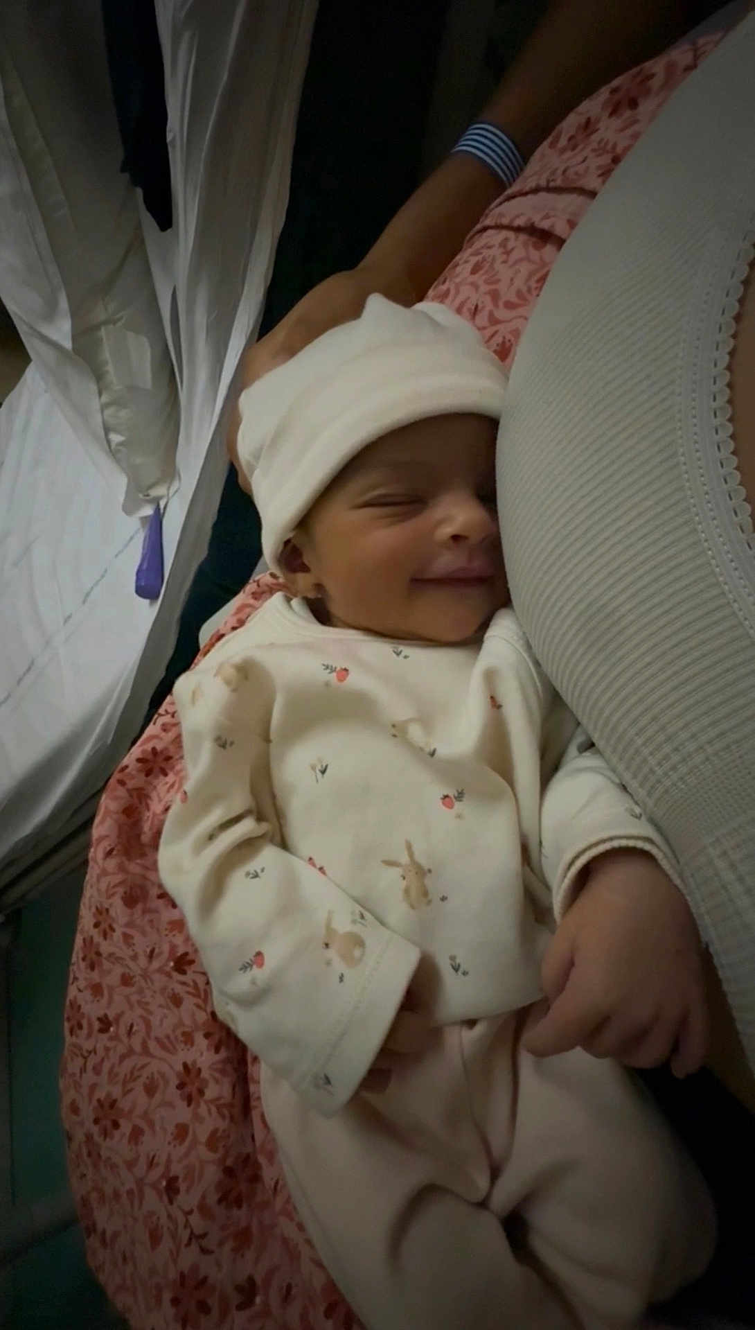 Adèle a rejoint le concours — aidez-le/la à gagner de superbes lots ! baby, newborn, sleeping, smiling, infant, hat, clothing, person, hand, blanket, pattern, floral, comfort, cozy, cute, resting, indoor, portrait, soft, tender