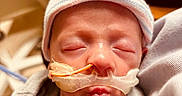 Holden joined the competition — help win amazing prizes! newborn, baby, infant, hospital, medical_tube, nasal_cannula, striped_cap, blanket, sleeping, face, closeup, skin, person, child, healthcare, indoors, soft_lighting, wrapped, cute, peaceful