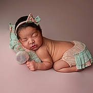 Olivia is registered to the contest to win money with this photo: baby, newborn, sleeping, headband, bow, pillow, lollipop, soft_toy, pastel_colors, pink_background, cute, infant, portrait, child, peaceful, studio_photo, props, skin, resting, adorable