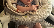 Dylan is registered to the contest to win money with this photo: baby, blanket, baby_chair, infant, cozy, expression, face, hair, patterned_fabric, sitting, indoor, cute, child, person, soft_texture, legs, feet, wrapped, comfortable, young