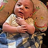 Dylan is registered to the contest to win money with this photo: baby, blanket, child, colorful, cozy, cute, expression, face, hands, ice_cream, indoors, infant, person, pillow, portrait, rainbow, resting, smiling, soft, young