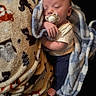 baby, blanket, pacifier, sleeping, infant, cozy, soft, patterned_blanket, comfort, child, wrapped, cute, nap, hand, foot, clothing, indoors, rest, warm, peaceful