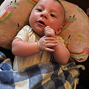 Dylan joined the competition — help win amazing prizes! baby, blanket, blue, checkered, child, clothing, comfort, cute, expression, face, hands, head, indoors, infant, lying_down, pillow, rainbow, skin, soft, white