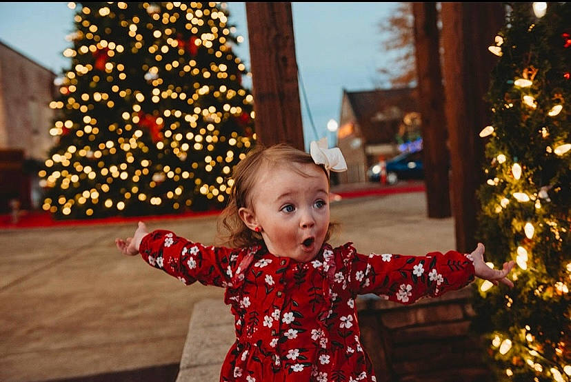 Annalyse joined the competition — help win amazing prizes! christmas, christmas_decoration, christmas_ornament, christmas_tree, event, fun, happy, holiday, holiday_ornament, leaf, light, lighting, ornament, person, plant, standing, surprise, toddler, tree, winter