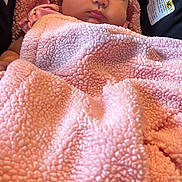 Alaia joined the competition — help win amazing prizes! baby, infant, blanket, pink, car_seat, face, child, soft_texture, cozy, portrait, indoor, warning_label, clothing, head, closeup, cute, young_child, sleepy, resting, newborn
