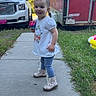 Everleigh is registered to the contest to win money with this photo: toddler, child, sidewalk, grass, boots, sippy_cup, white_shirt, polka_dot_leggings, red_trailer, white_truck, outdoor, daylight, trees, smiling, person, vehicle, concrete, nature, playful, casual_clothing