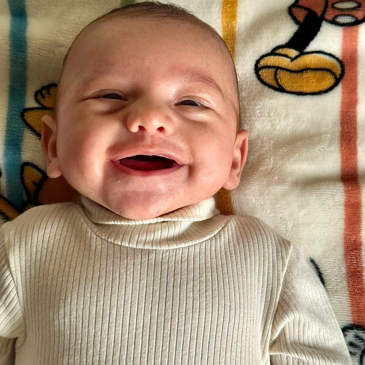 Imraan a rejoint le concours — aidez-le/la à gagner de superbes lots ! baby, blanket, cartoon, child, closeup, cute, face, happy, head, indoors, infant, lying_down, mouth_open, portrait, ribbed_clothing, skin, smile, sweater, toddler, warm_clothing