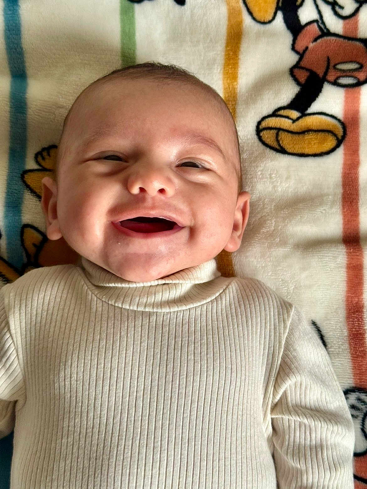 Imraan a rejoint le concours — aidez-le/la à gagner de superbes lots ! baby, smile, infant, sweater, ribbed_clothing, lying_down, blanket, cartoon, cute, happy, child, face, portrait, closeup, indoors, skin, head, mouth_open, warm_clothing, toddler