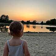 Louana participe au concours pour gagner de l'argent avec cette photo : toddler, child, lake, sunset, sand, water, nature, outdoor, trees, sky, reflection, peaceful, calm, summer, evening, bare_skin, tank_top, back_view, landscape, serene