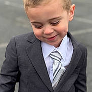 Lorenzo is registered to the contest to win money with this photo: child, boy, suit, tie, smile, portrait, outdoor, cute, fashion, formal, young, person, short_hair, happy, face, clothing, standing, background_blur, dimple, casual