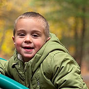 Lorenzo joined the competition — help win amazing prizes! child, boy, smile, face, portrait, green_jacket, jacket, outdoor, autumn, bokeh, close_up, happy, playground, park, short_hair, eyes, hood, zipper, cheeks, soft_lighting
