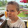 Lorenzo joined the competition — help win amazing prizes! child, boy, face, expression, indoor, window, table, drink, straw, shirt, greenery, picnic_table, outdoor, daylight, hair, smirk, casual_clothing, seat, restaurant, funny_face
