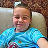 Lorenzo is registered to the contest to win money with this photo: child, boy, smile, blue_shirt, tablet, chair, carpet, indoor, happy, face, person, technology, casual_clothing, leisure, playful, young, portrait, sitting, home, relaxation