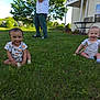 baby, grass, outdoor, smiling, child, house, person, greenery, sunny_day, sitting, happy, footwear, table, window, air_conditioner, clothing, nature, yard, daytime, playful