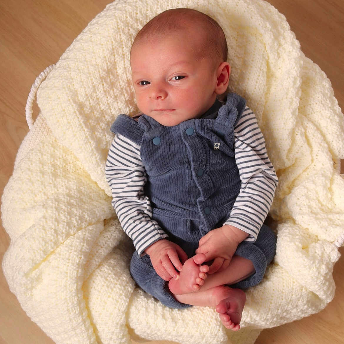 Gaël a rejoint le concours — aidez-le/la à gagner de superbes lots ! baby, blanket, blue_overalls, child, clothing, cute, face, feet, hands, head, indoors, infant, knitted_blanket, newborn, peaceful, portrait, sleepy, striped_shirt, wooden_floor, young
