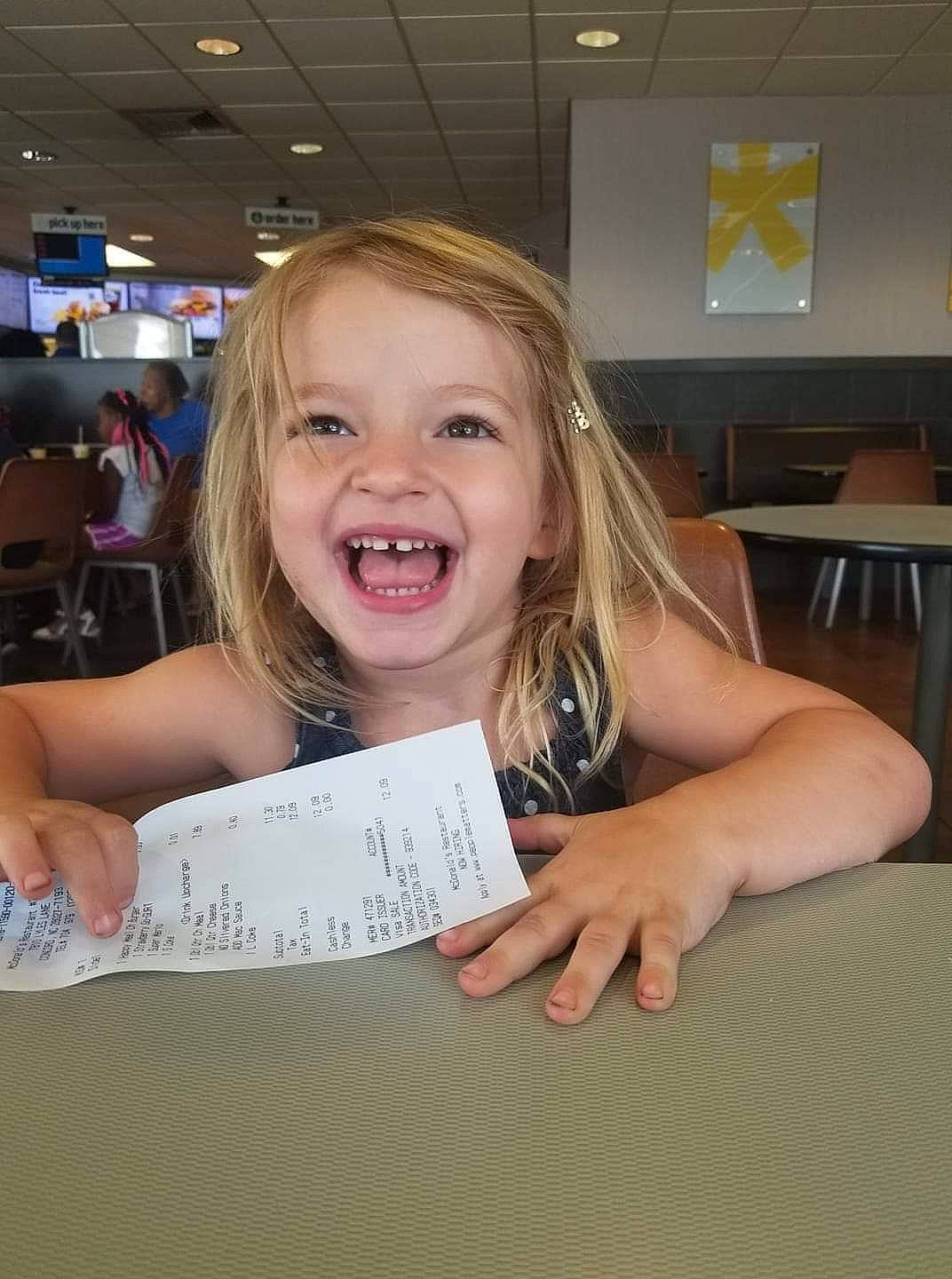 Ryleigh is registered to the contest to win money with this photo: blond, child, facial_expression, finger, fun, joy, person, room, smile, tooth, under_exposed