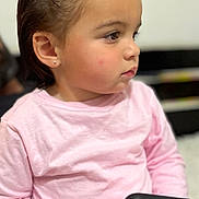 Lissa Kolotian a rejoint le concours — aidez-le/la à gagner de superbes lots ! child, toddler, girl, portrait, profile, pink_shirt, hair_bow, earring, holding_phone, smartphone, sitting, indoor, cute, chubby_cheeks, side_view, focused, blurry_background, casual_clothing, young_child, closeup