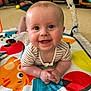baby, smiling, play_mat, indoor, child, happy, infant, face, toy, colorful, pattern, clothing, hands, head, floor, couch, home, cute, portrait, baby_girl