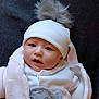 Lynna a rejoint le concours — aidez-le/la à gagner de superbes lots ! baby, child, infant, hat, pom_pom, white_clothing, knitwear, face, portrait, cute, warm, cozy, indoor, expression, looking, person, soft_texture, newborn, headwear, small