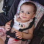 baby, child, smiling, stroller, seatbelt, cute, indoors, infant, clothing, dimple, face, person, happy, pink, pattern, sitting, young_child, cute_outfit, comfort, baby_girl