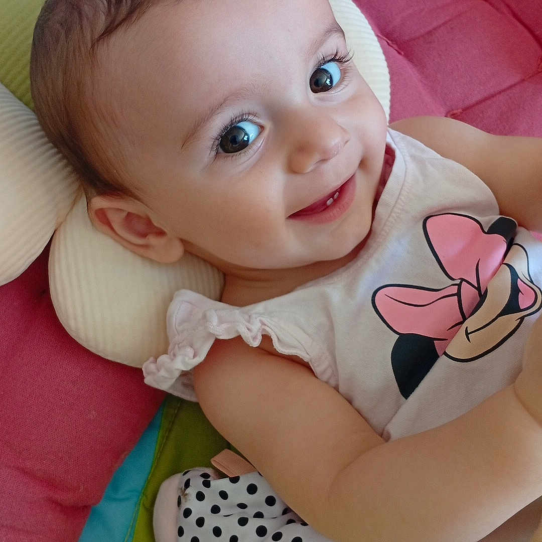 Gabie a rejoint le concours — aidez-le/la à gagner de superbes lots ! baby, blanket, child, clothing, colorful, cushion, cute, eyes, face, happy, indoors, infant, lying_down, minnie_mouse, pillow, polka_dot, portrait, smiling, soft_toy, toy