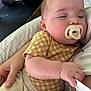 James joined the competition — help win amazing prizes! baby, sleeping, pacifier, infant, checkered_shirt, arm, hand, clothing, cozy, quilted, closeup, face, skin, person, resting, indoor, meal, table, relaxing, comfort