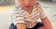 Rayshan is registered to the contest to win money with this photo: black_cap, bracelet, cap, casual_clothing, child, couch, curious, indoors, living_room, natural_light, person, playing, red_toy, shorts, sitting, striped_shirt, toddler, toy, window, young_child
