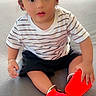 Rayshan joined the competition — help win amazing prizes! toddler, child, cap, striped_shirt, black_shorts, red_shoes, couch, indoor, sitting, curious, face, person, casual_clothing, cute, wide_eyes, bracelet, footwear, home, portrait, young_child