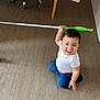 barefoot, blue_jeans, casual_clothing, child, cleaning_tool, curly_hair, cute, floor, happy, home, indoor, mop, person, playful, smiling, toddler, toy, white_shirt, wooden_floor, young_child