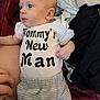 Chance is registered to the contest to win money with this photo: baby, baby_boy, baby_girl, casual, clothing, cute, fabric, face, hand, indoor, infant, lying_down, newborn, onesie, person, pile_of_clothes, remote_control, sitting, soft_texture, text_on_clothing