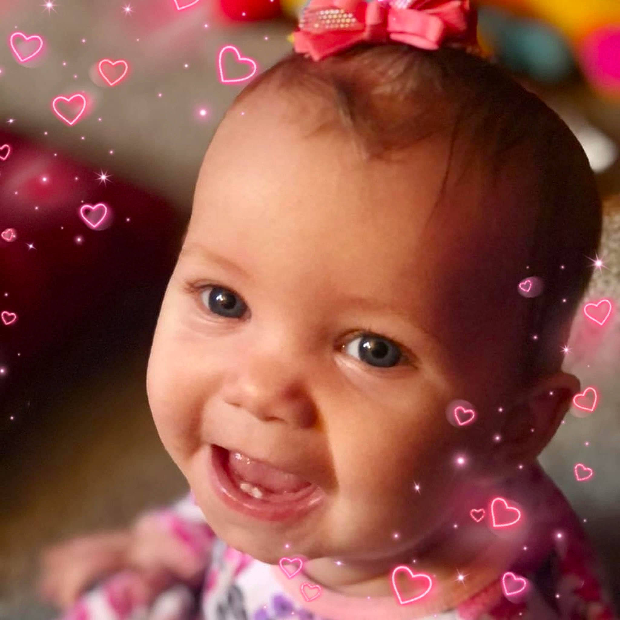 Kaylee is registered to the contest to win money with this photo: cheek, chin, ear, eye, eyebrow, eyelash, face, happy, head, iris, lip, magenta, nose, organ, person, pink, purple, skin, smile, toddler