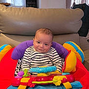 Maylone a rejoint le concours — aidez-le/la à gagner de superbes lots ! baby, child, smiling, striped_shirt, colorful, toy, cushioned_seat, indoor, living_room, happy, person, young_child, play, seat, cute, infant, comfortable, bright_colors, face, portrait