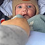 Theo is registered to the contest to win money with this photo: baby, child, hat, knit_hat, bear_design, blue_eyes, blanket, hand, clothing, cute, surprised, portrait, closeup, infant, face, person, warm, soft, indoors, cozy