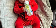 Hudson joined the competition — help win amazing prizes! baby, bottle, red_clothing, hat, blanket, sleeping, infant, person, footed_pajamas, indoor, cute, resting, child, feeding, cozy, soft_texture, newborn, relaxing, sleep, comfort
