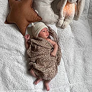 Victoire a rejoint le concours — aidez-le/la à gagner de superbes lots ! baby, newborn, infant, blanket, plush_bunny, star_pillow, crescent_pillow, beanie, leopard_wrap, soft_texture, cozy, lying_down, tiny_toes, hand, gaze, nursery, stuffed_animal, fabric, portrait, indoor