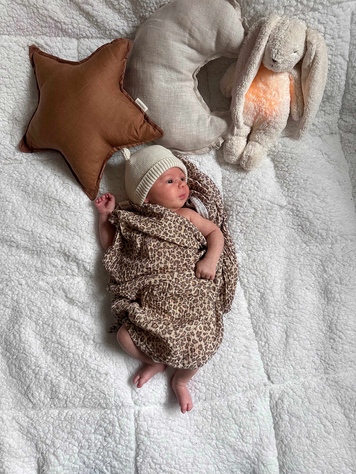 Victoire a rejoint le concours — aidez-le/la à gagner de superbes lots ! baby, newborn, infant, blanket, plush_bunny, star_pillow, crescent_pillow, beanie, leopard_wrap, soft_texture, cozy, lying_down, tiny_toes, hand, gaze, nursery, stuffed_animal, fabric, portrait, indoor