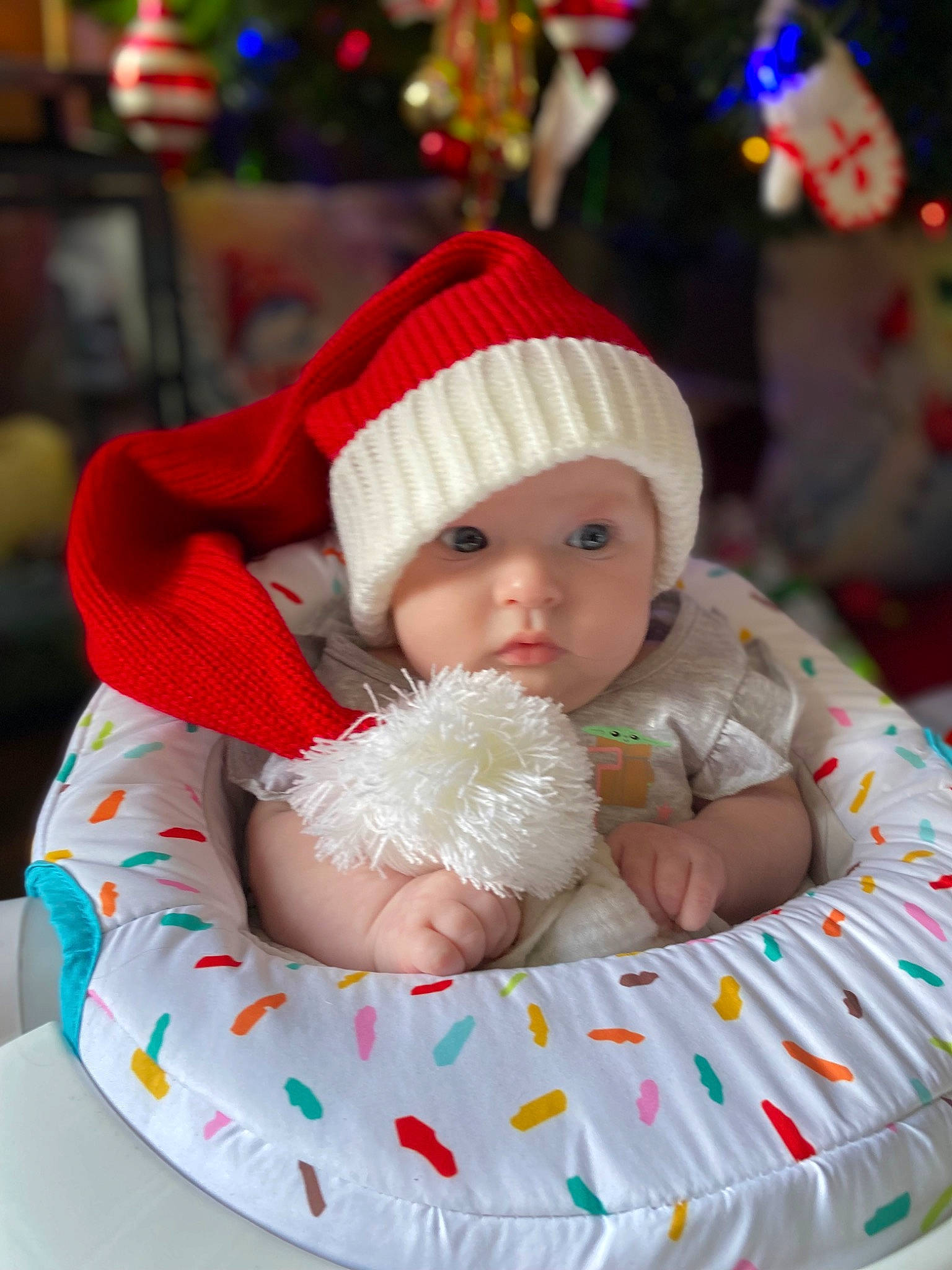 Elena is registered to the contest to win money with this photo: baby, baby_toddler_clothing, cap, child, christmas, christmas_decoration, costume_hat, event, green, happy, hat, headgear, headwear, holiday, knit_cap, person, plant, red, santa_claus, skin